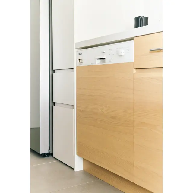 食洗機はミーレ。バックカウンター側の扉はすべてオーク材ウレタン塗装。木目がつながるように美しく仕上げている