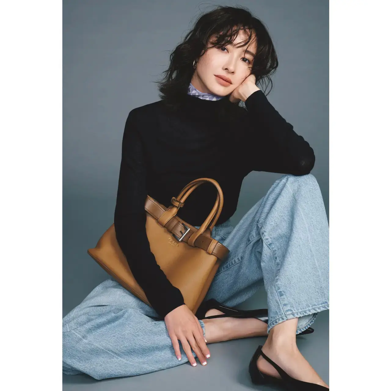 柄スカーフをコンパクトに効かせて、シンプルな黒タートルを鮮度高く着こなす。