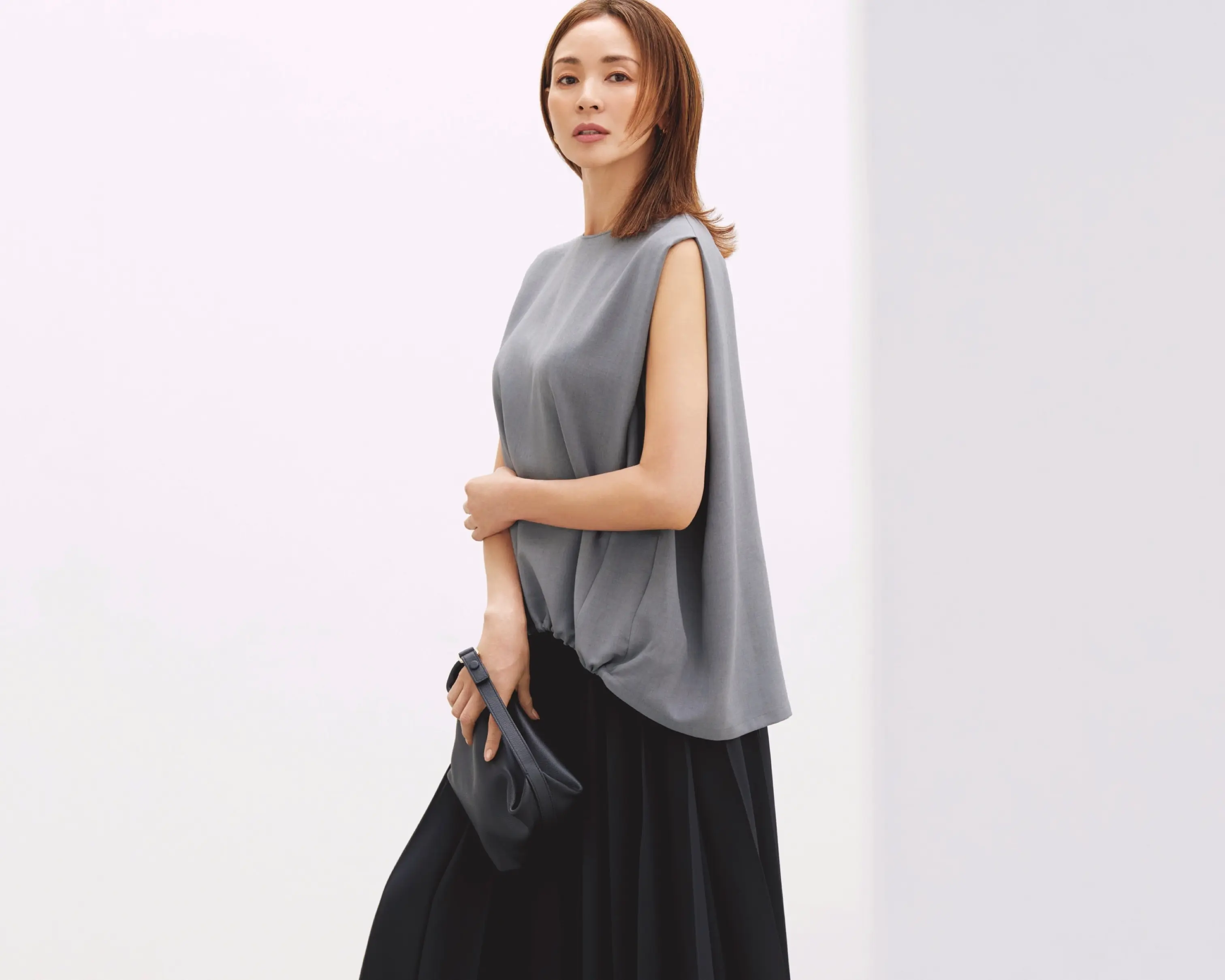 グレーノースリーブトップスに黒ロングスカートを合わせたコーディネート モデル・SHIHO