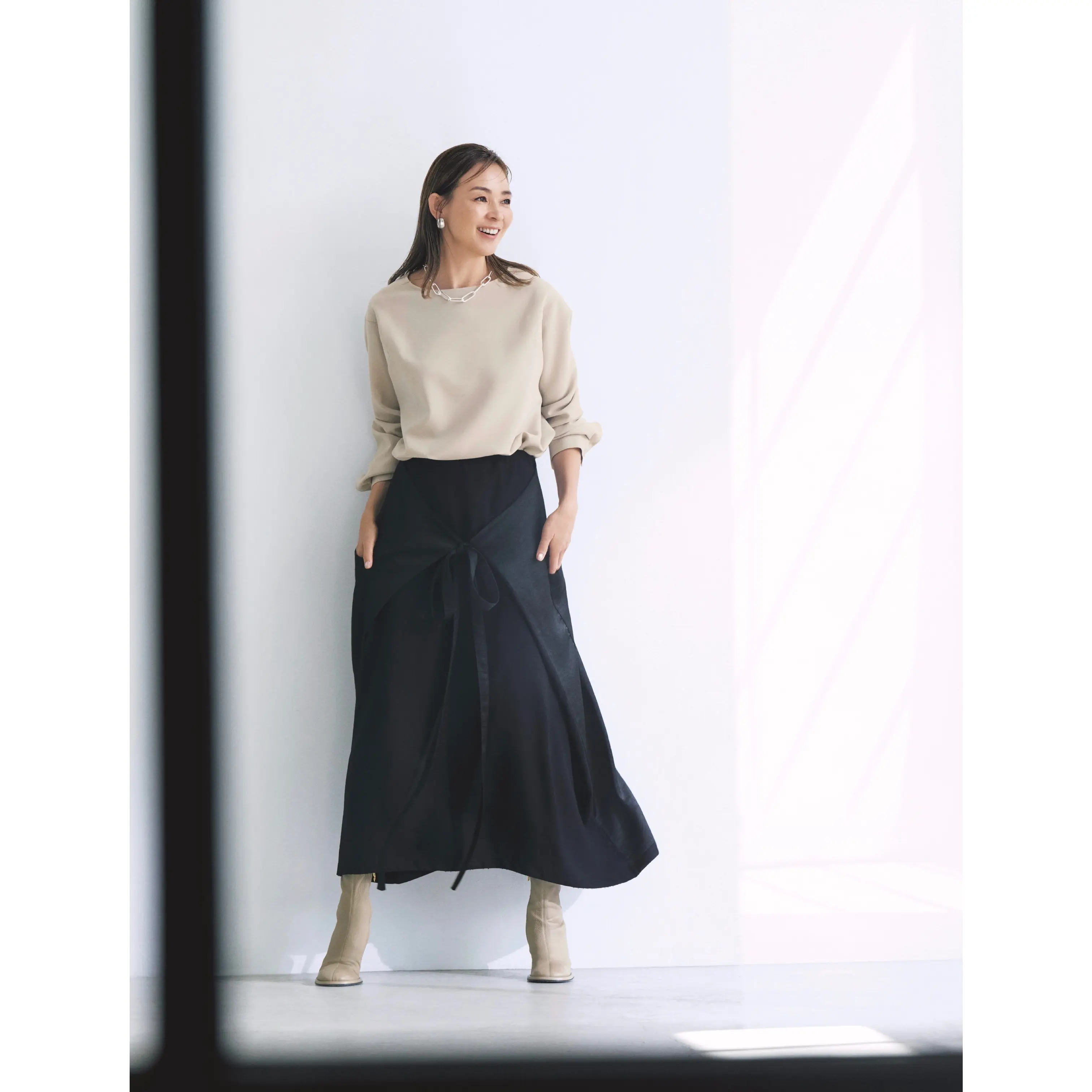 ベージュトップスに黒ラップデザインスカートを合わせたコーディネート モデル・SHIHO