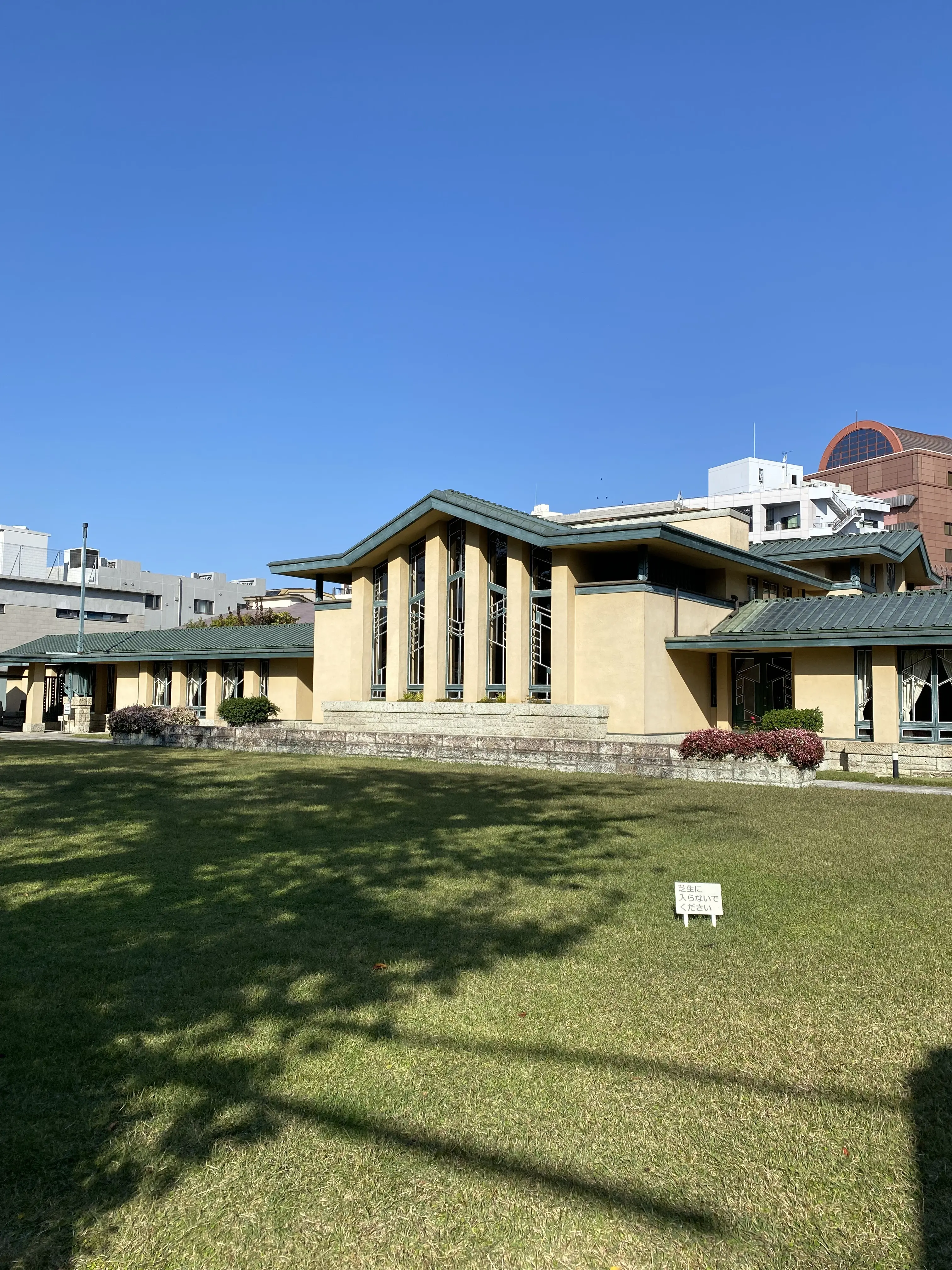 自由学園明日館の外観と芝生の庭園。フランク・ロイド・ライト設計の歴史的建築。