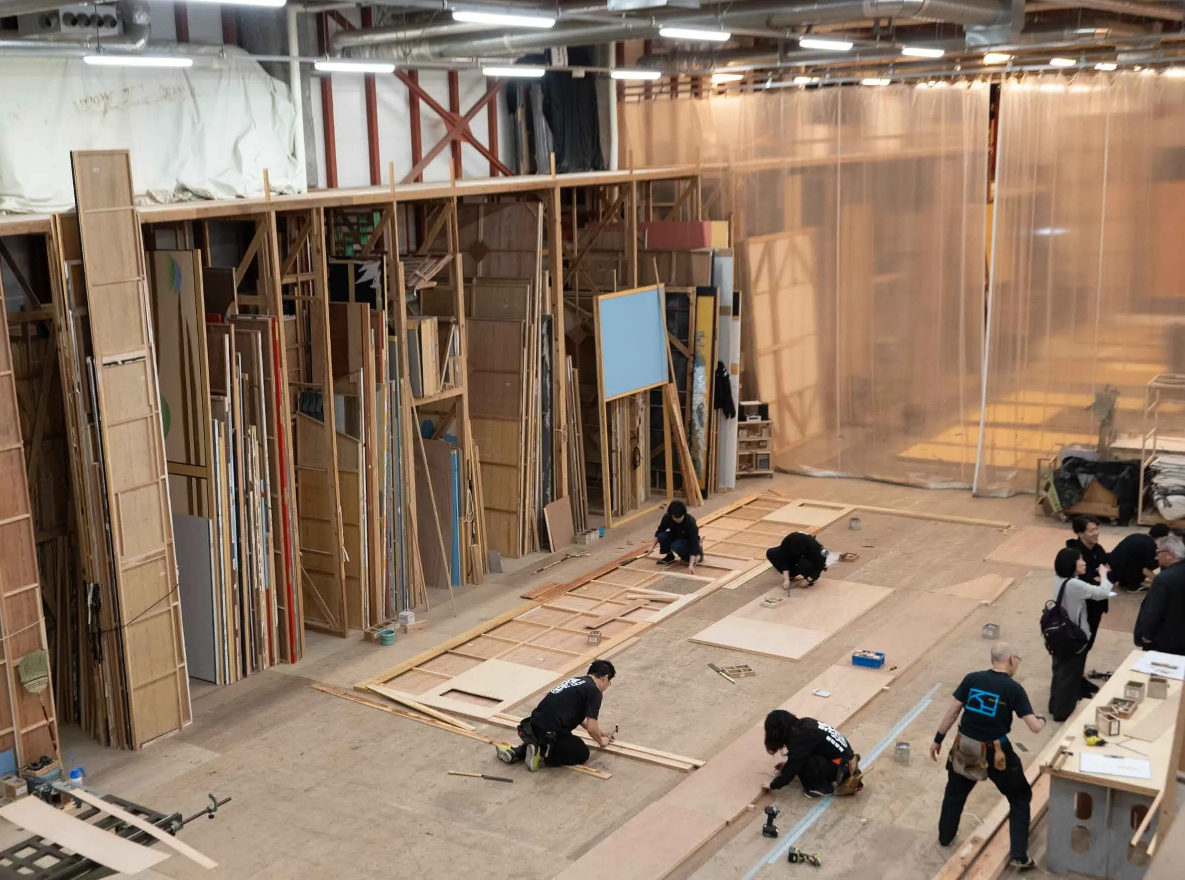 のこぎりで木を切る音や釘を打つ音が鳴り響く制作現場