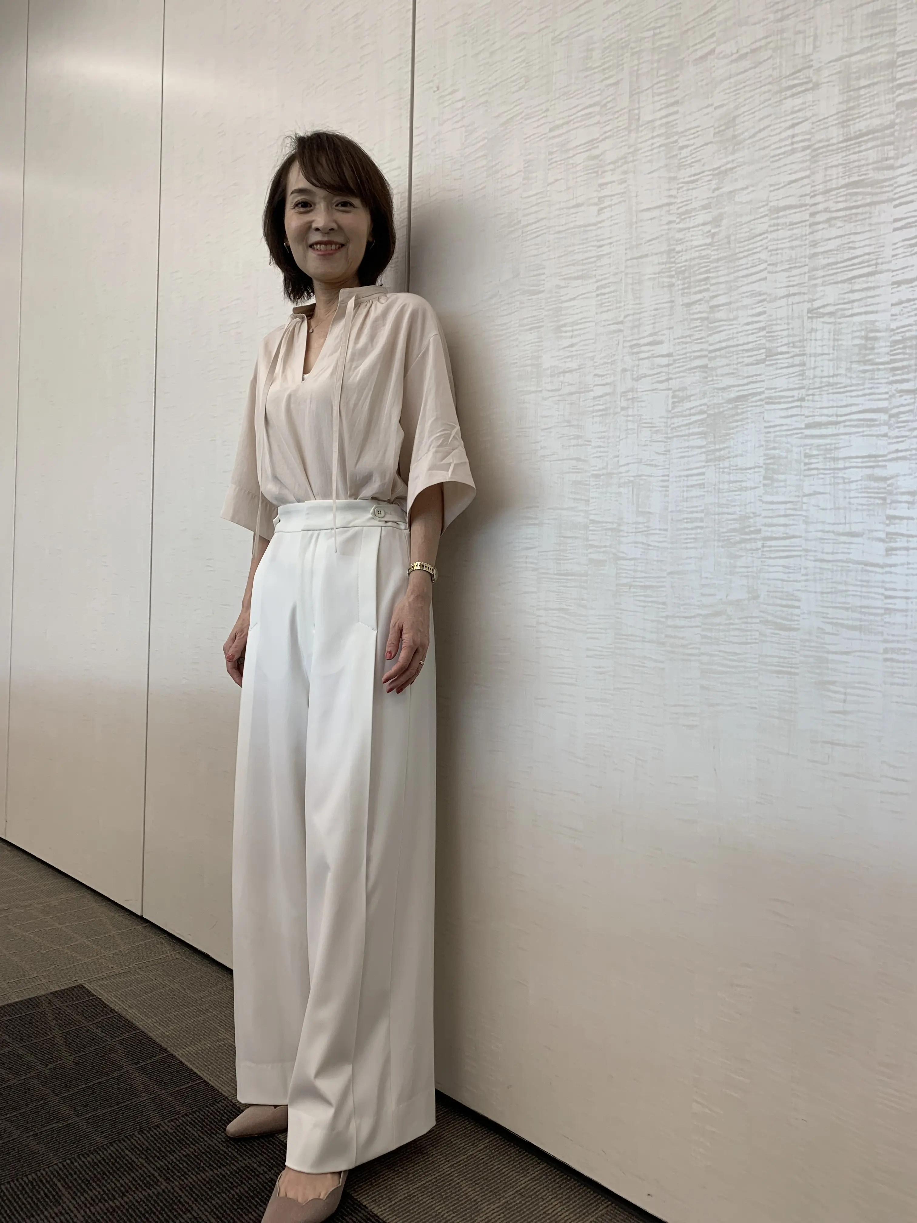優美なセミワイドパンツ（白）を着用した女性