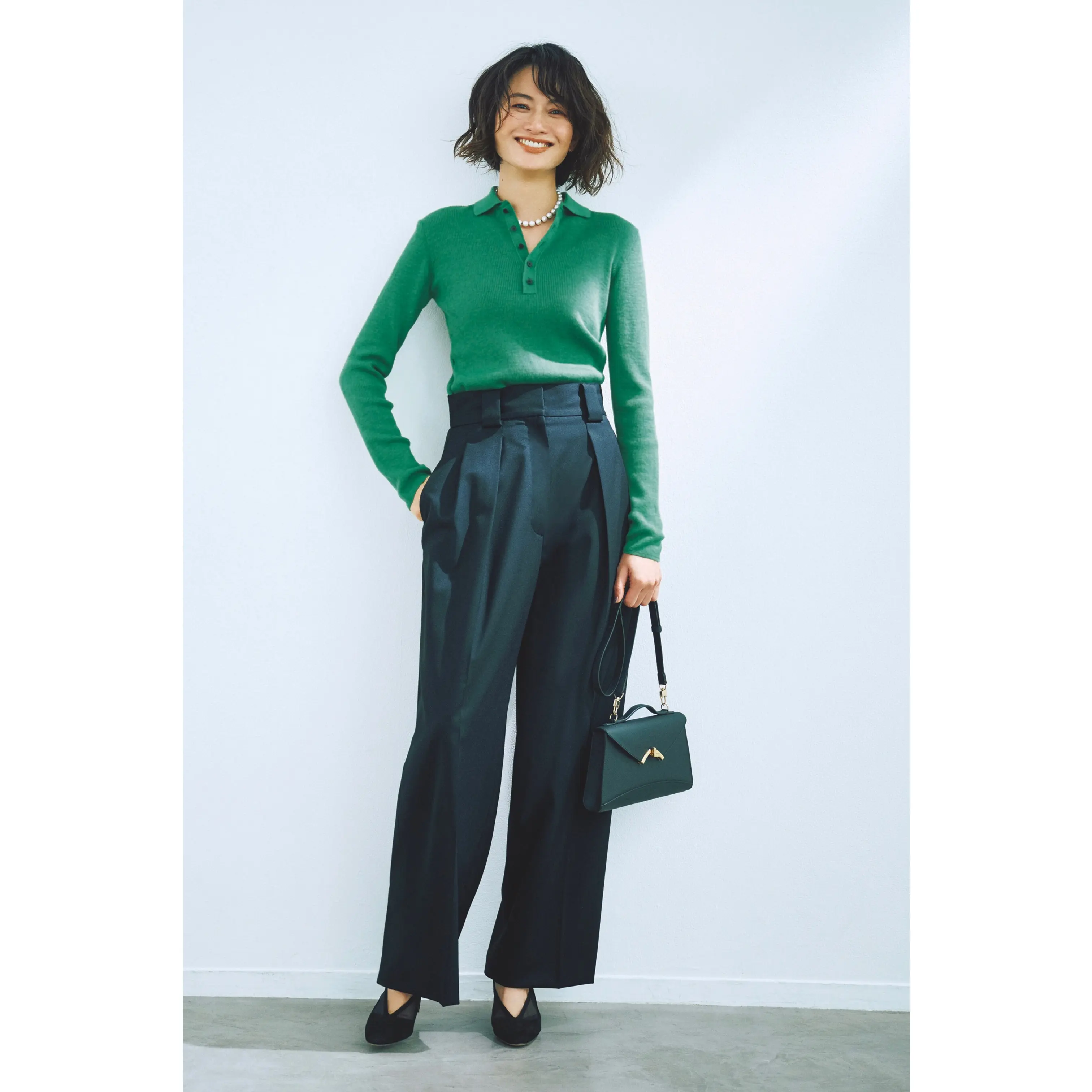 グリーンポロニットに黒タックパンツを合わせたコーディネート　モデル・渡辺佳子