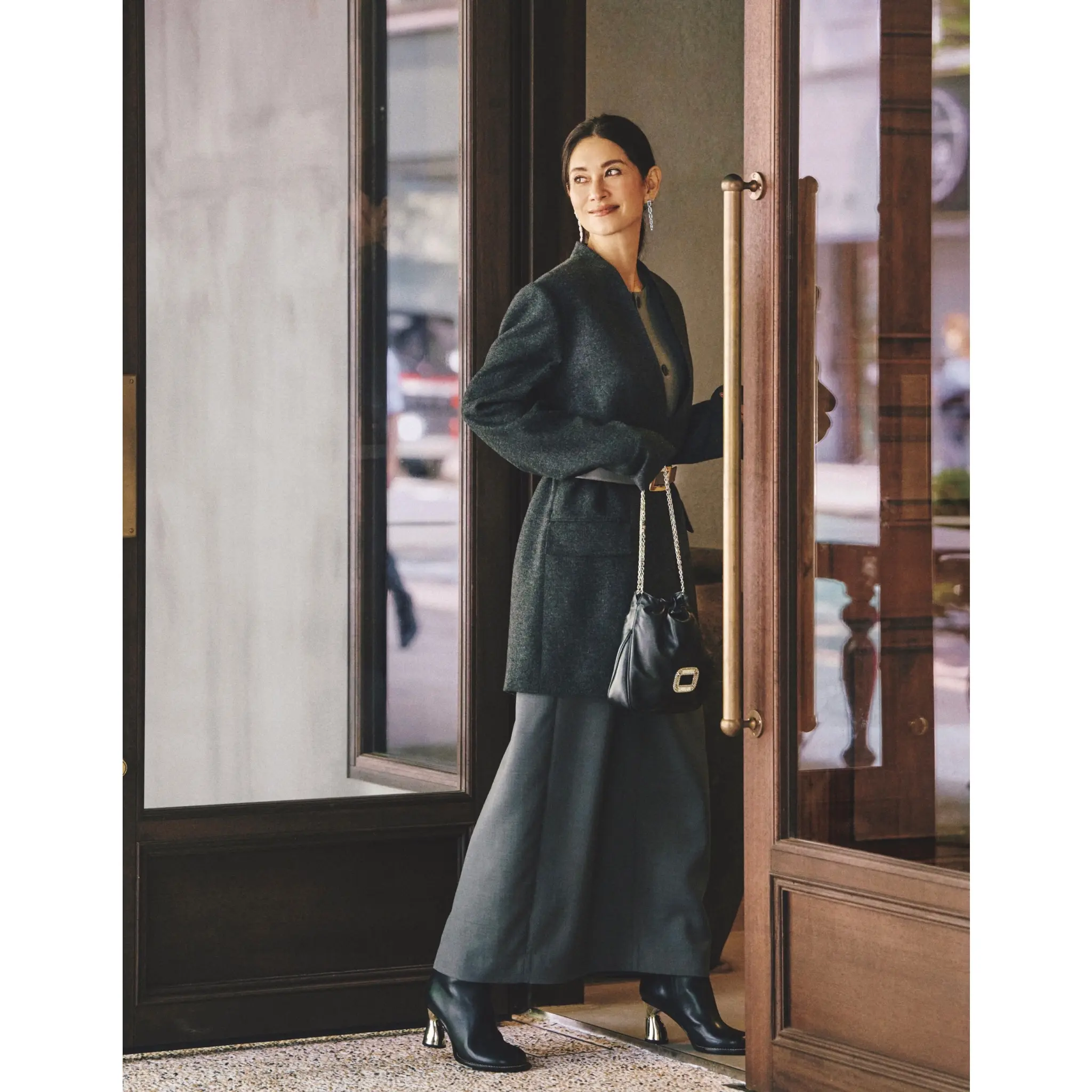 ダークグレーのノーカラージャケットコートの上からレザーベルトを締め、グレーロングスカートを合わせたコーディネート　モデル・ブレンダ