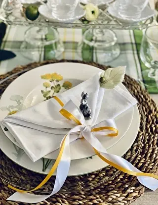 テーブルナプキンに白と黄色のリボンを結んでいます。