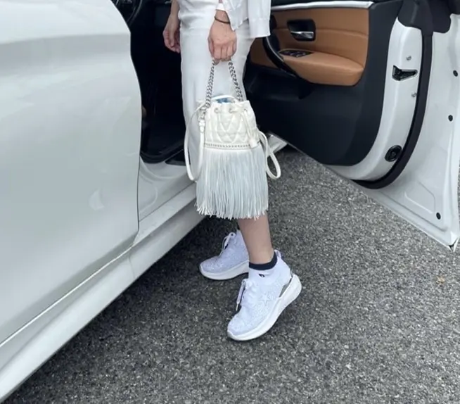 女性足元の写真　白いバッグと白いスニーカー