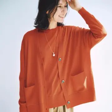 鮮やかなオレンジのアンサンブルニットは、まろやかなベージュパンツで上品に着こなす。気温13℃｜12/8(月)【50代の毎日コーデ】