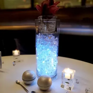 テーブルに置かれたライトアップされた花瓶。