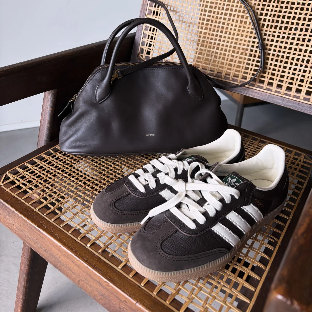 ブラウンのバッグとアディダスシューズ