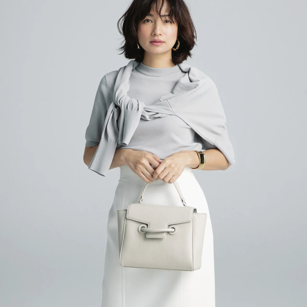 四角いバッグを持つモデルの佐田真由美さん