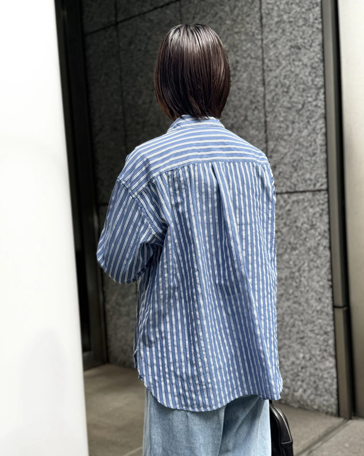 透けストライプボウタイ付きシャツ　デニムパンツのコーデ後ろから