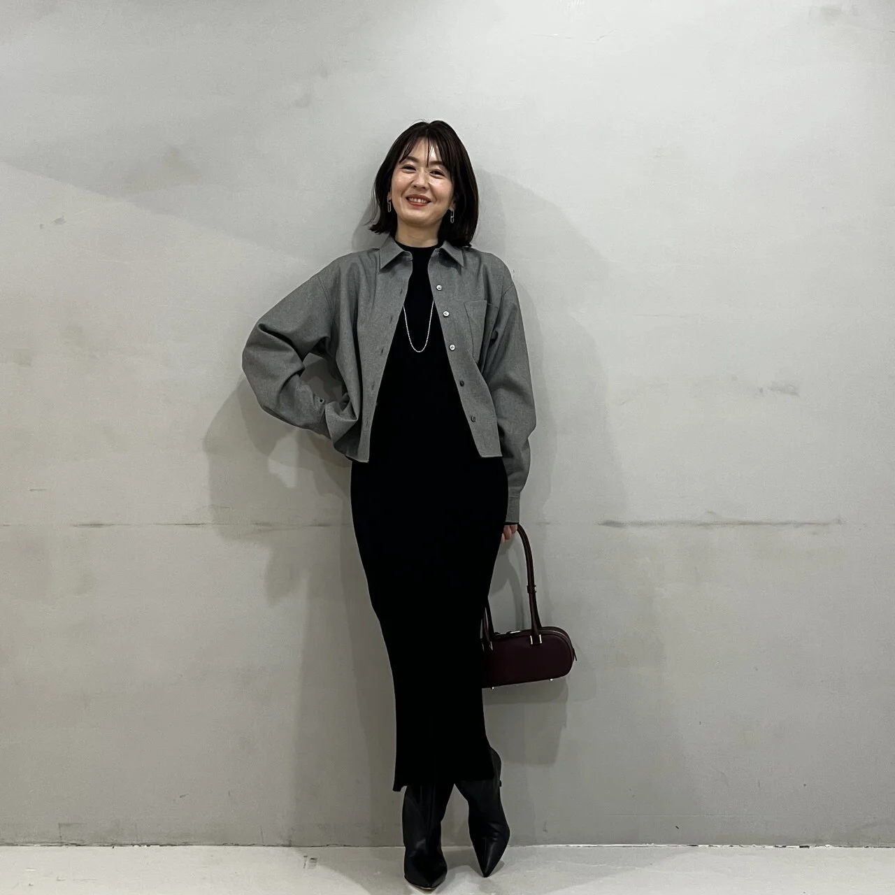 黒いワンピースにツイード風シャツのグレーを合わせたコーデ
