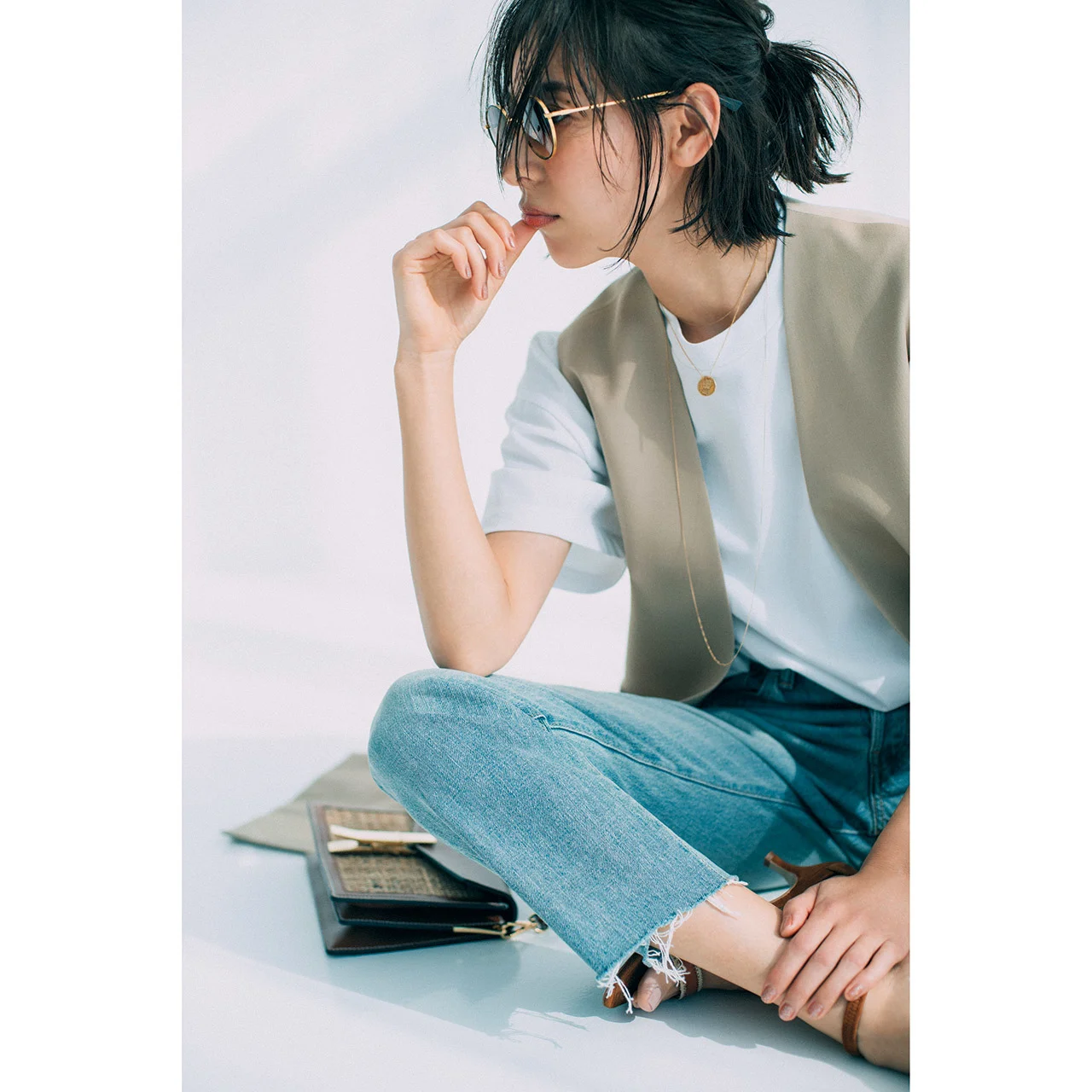 コインネックレス×白Tシャツ×ベスト×デニムパンツコーデを着たモデルの小泉里子さん