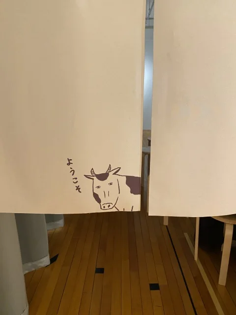 写真展の入り口は和田ラヂヲさんが描いたであろう牛ののれんがお出迎え。……牛腸だから牛なのか、と今気が付く。