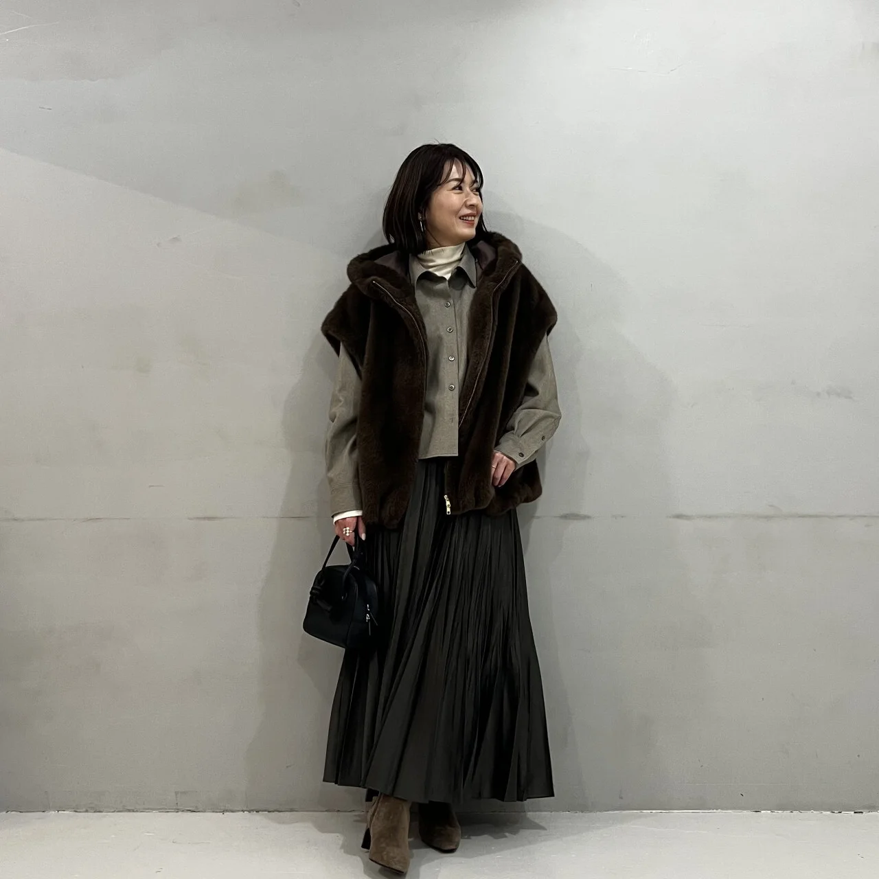 黒いスカートにツイード風シャツのベージュを合わせたコーデ