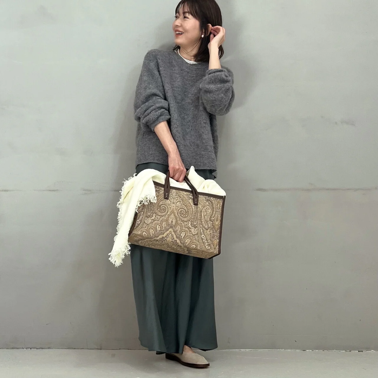 モヘア混ふわ軽コンパクトニットにグレーのロングスカートとバッグのコーデ