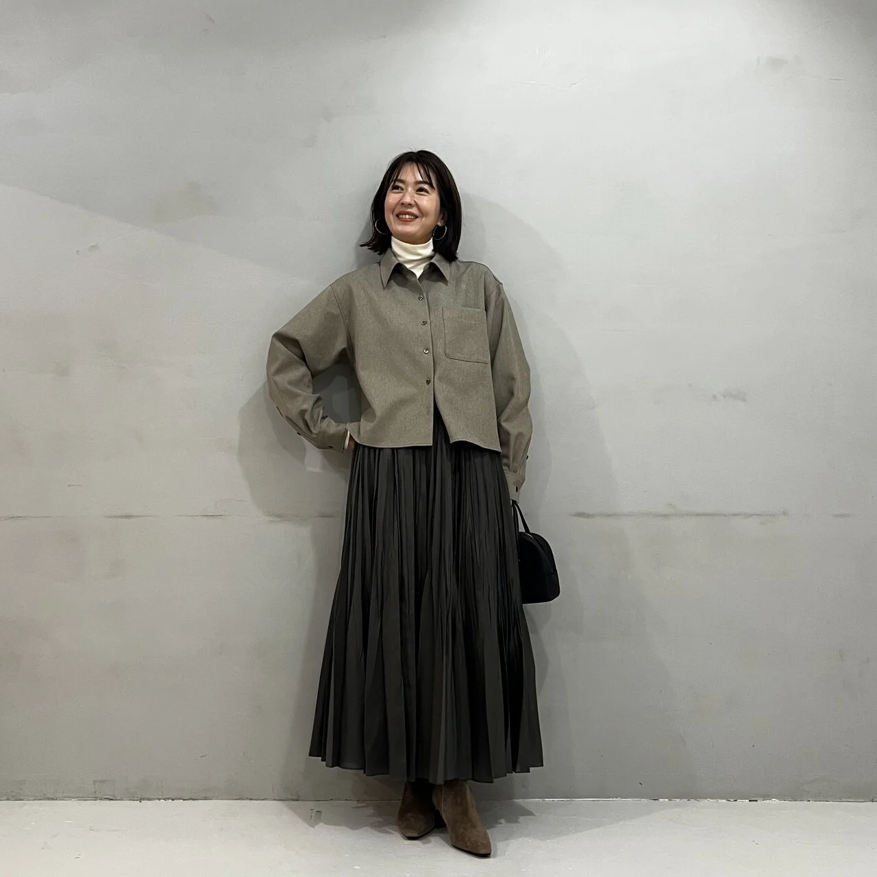 黒いスカートにツイード風シャツのベージュを合わせたコーデ