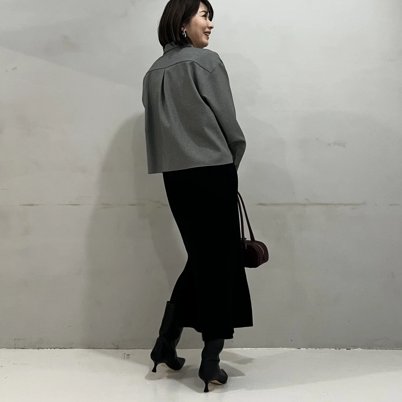 黒いワンピースにツイード風シャツのグレーを合わせたコーデ　バックスタイル