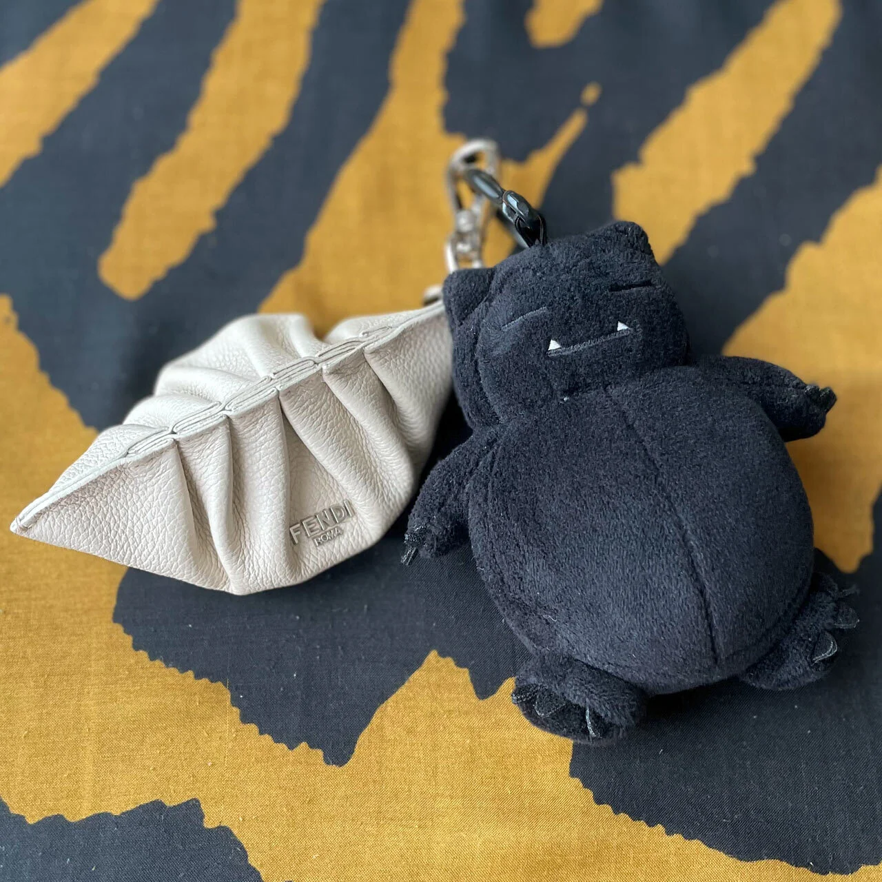 「FENDI」の餃子チャームと、黒カビゴンのチャーム