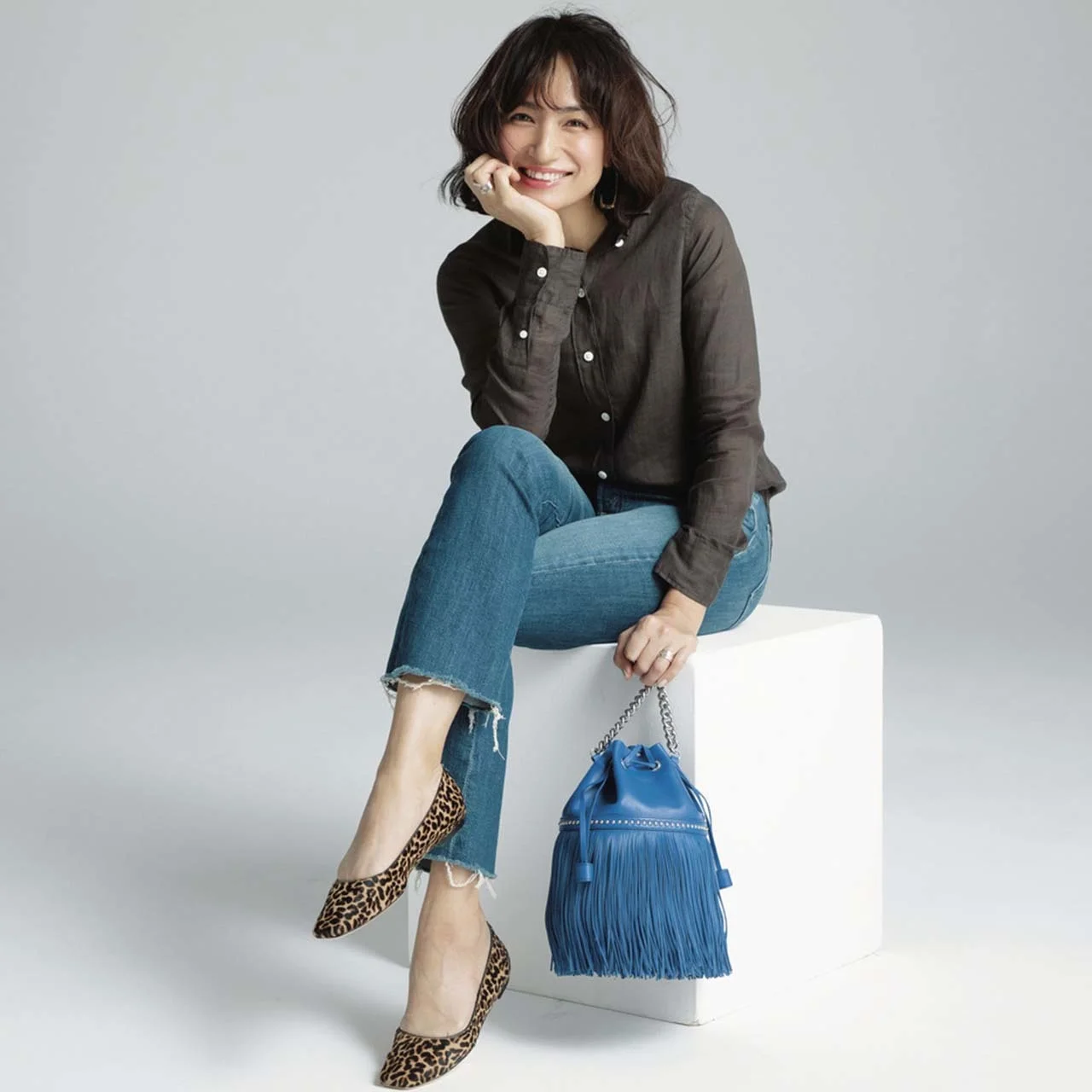 筒型バッグを持つモデルの佐田真由美さん