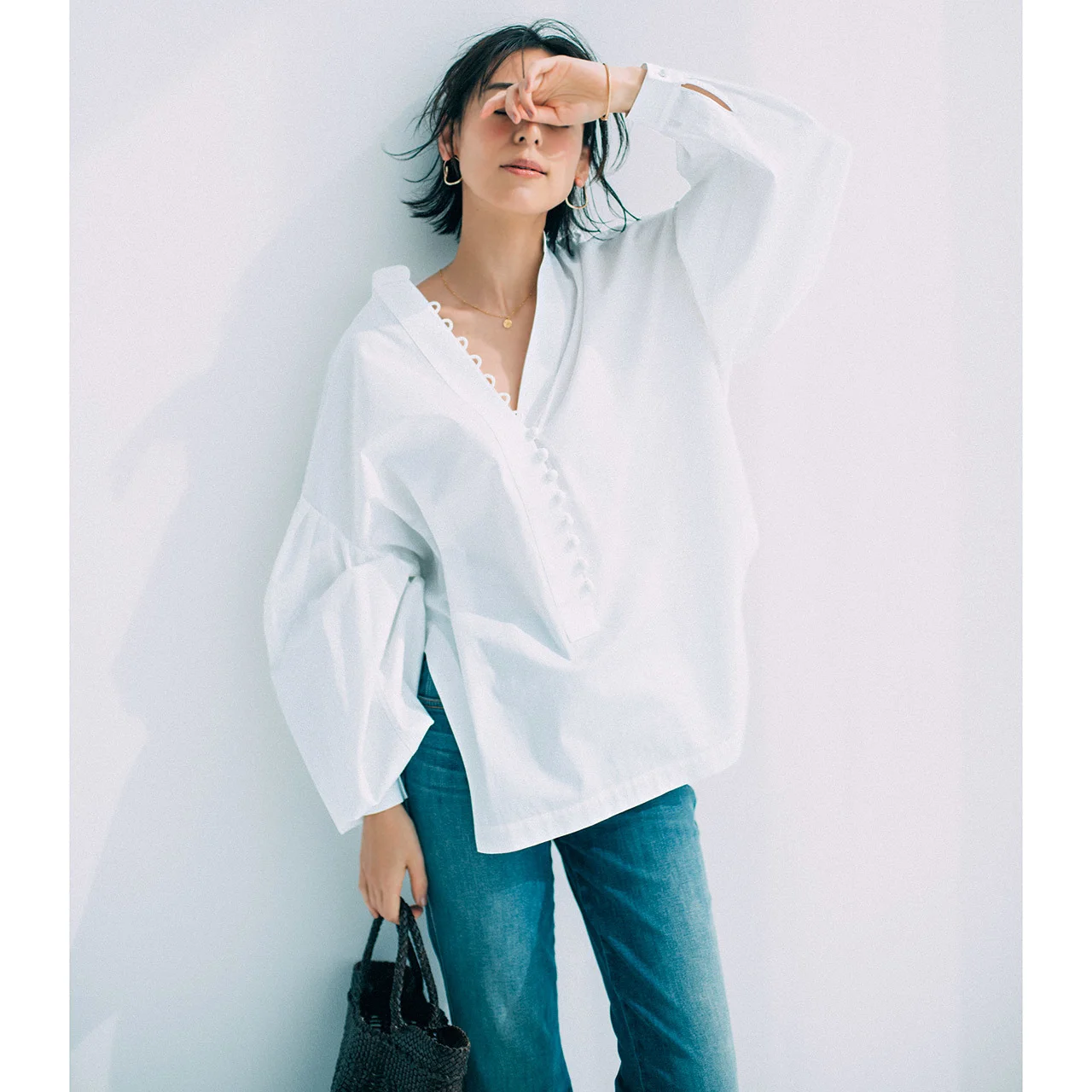デザインのきいた白シャツ×デニムパンツコーデを着たモデルの小泉里子さん