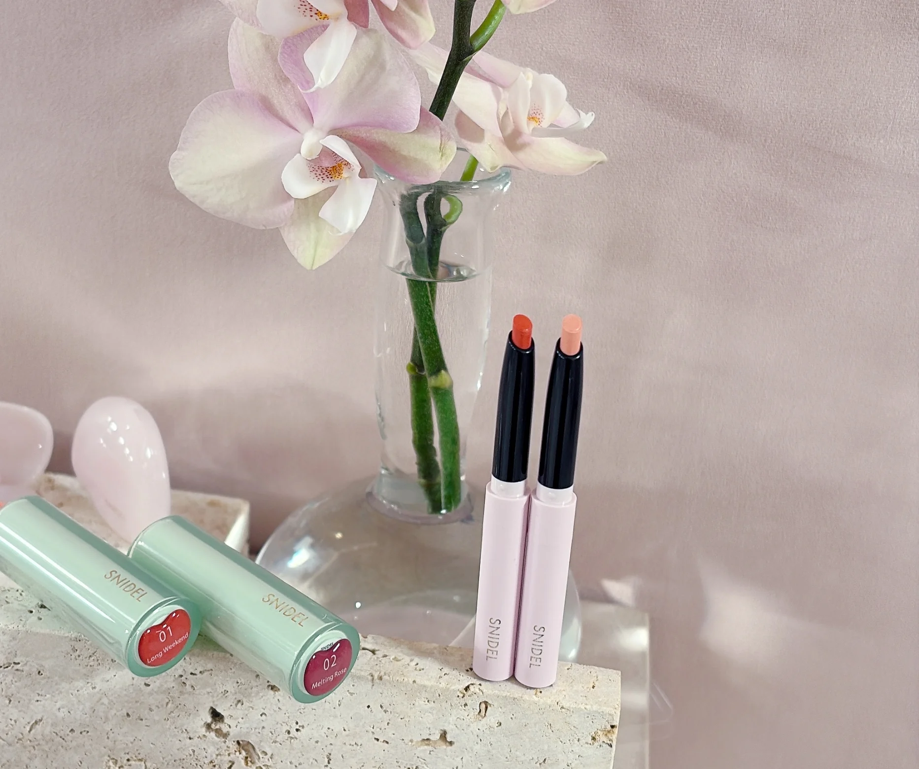 2026 新作コスメ　右のEX01は、上唇の山や口角にひと塗りすれば、ぷっくりとした立体感をもたらすシャイニーベージュ。EX02のシアーなコーラルは絶妙な血色感と彩度できっちりしすぎず、じんわり、でも唇のフレームを美しく整えるのにぴったり。この１本で唇を塗りつぶしても絶対可愛い！   ピュア リップ シェイパー n　限定２色　各￥2530／スナイデル ビューティ＜2026年１月１日（木）数量限定発売＞＊予約受付中