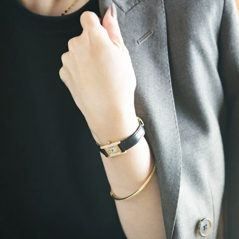 徳原さんの手もとには、カルティエの腕時計とゴールドの細いバングルが光る。