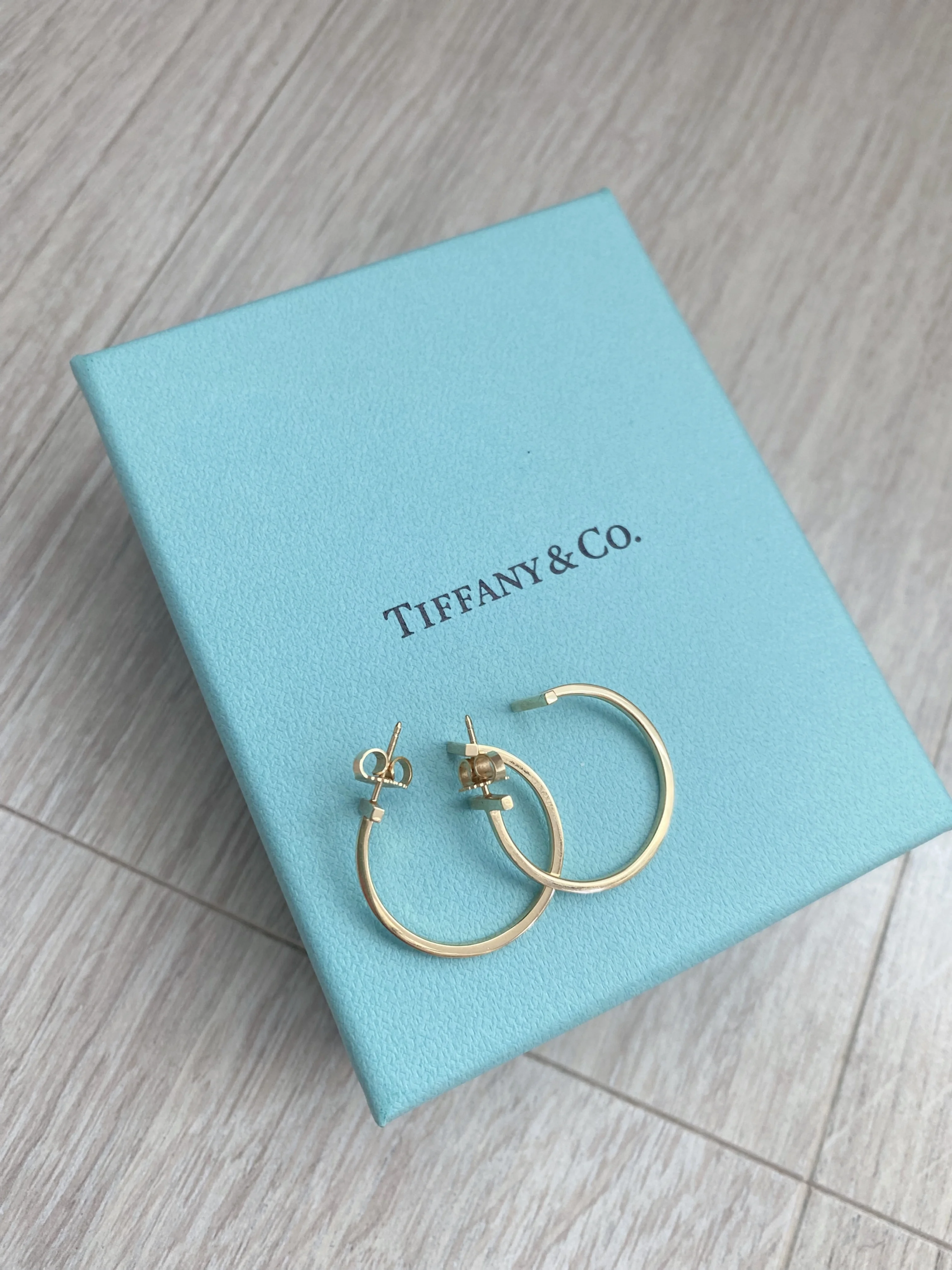 憧れを日常に。Tiffany「T ワイヤーフープピアス」