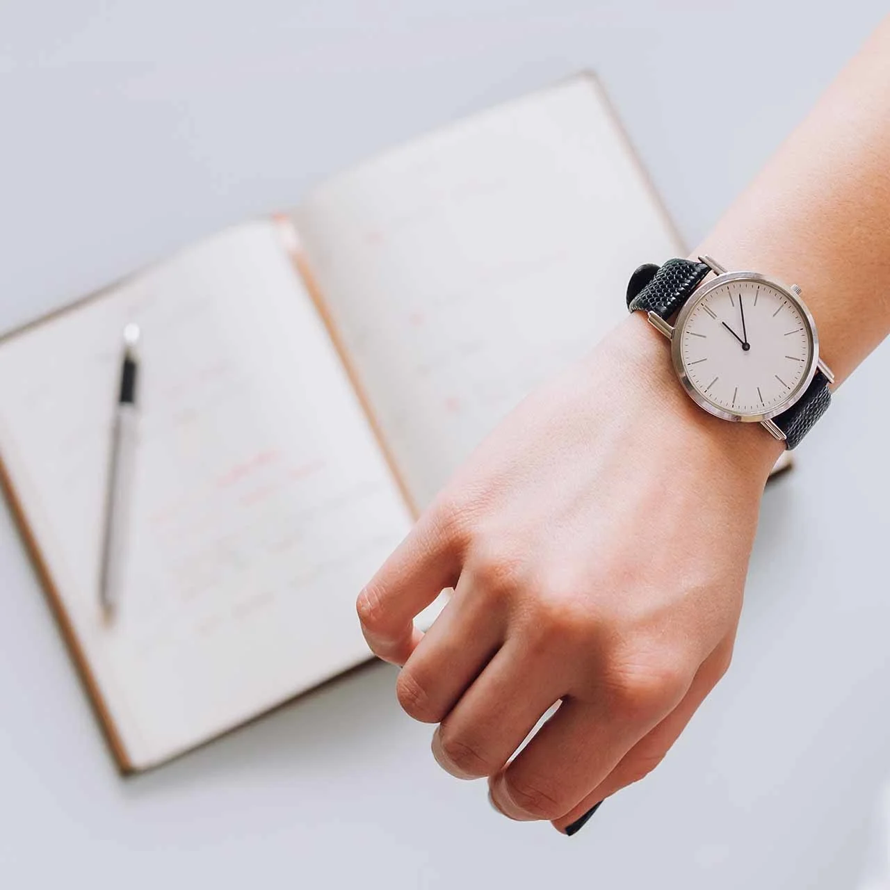 スケジュール管理をする女性の手帳と腕時計
