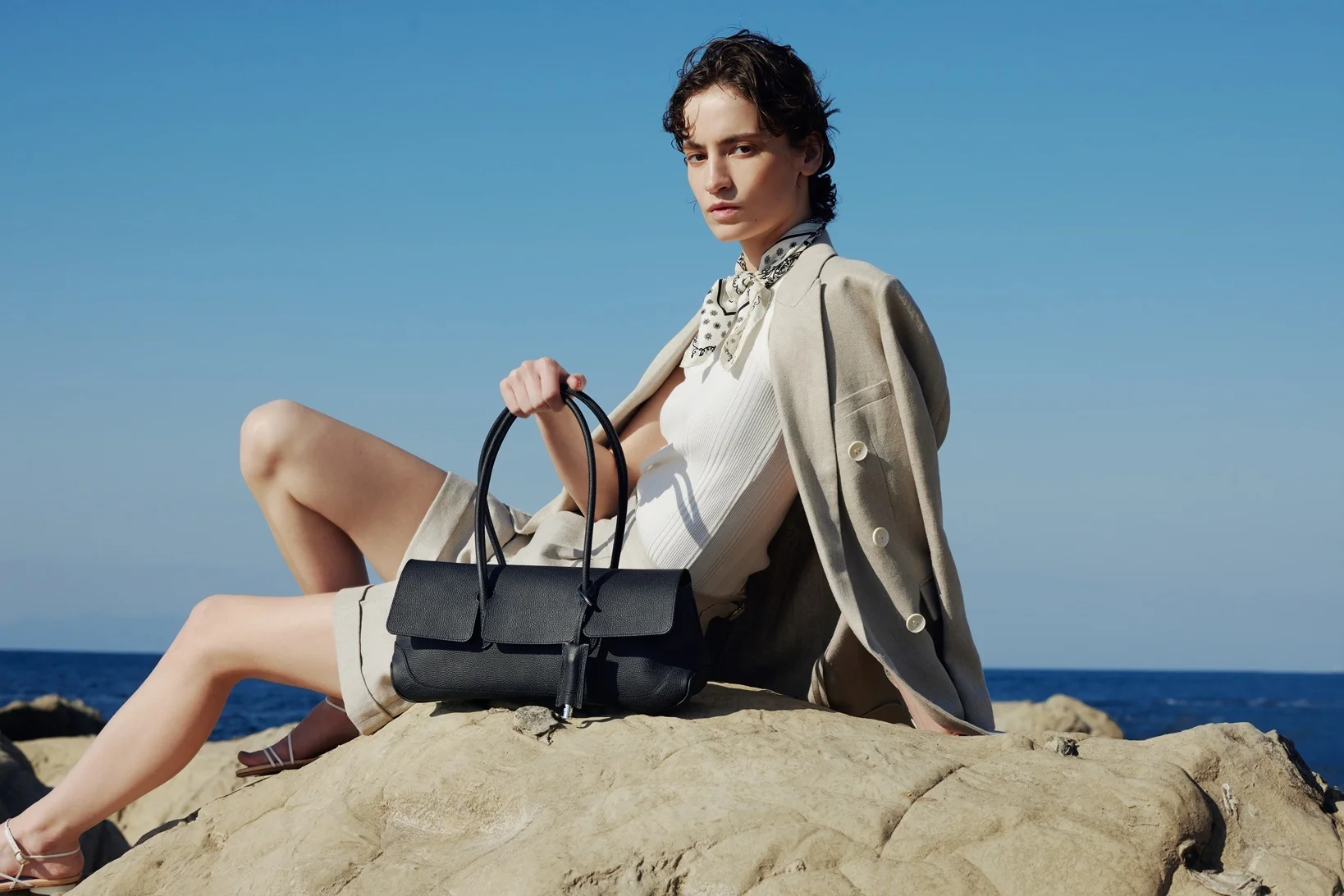 スモールのフラップトートバッグを持つモデル