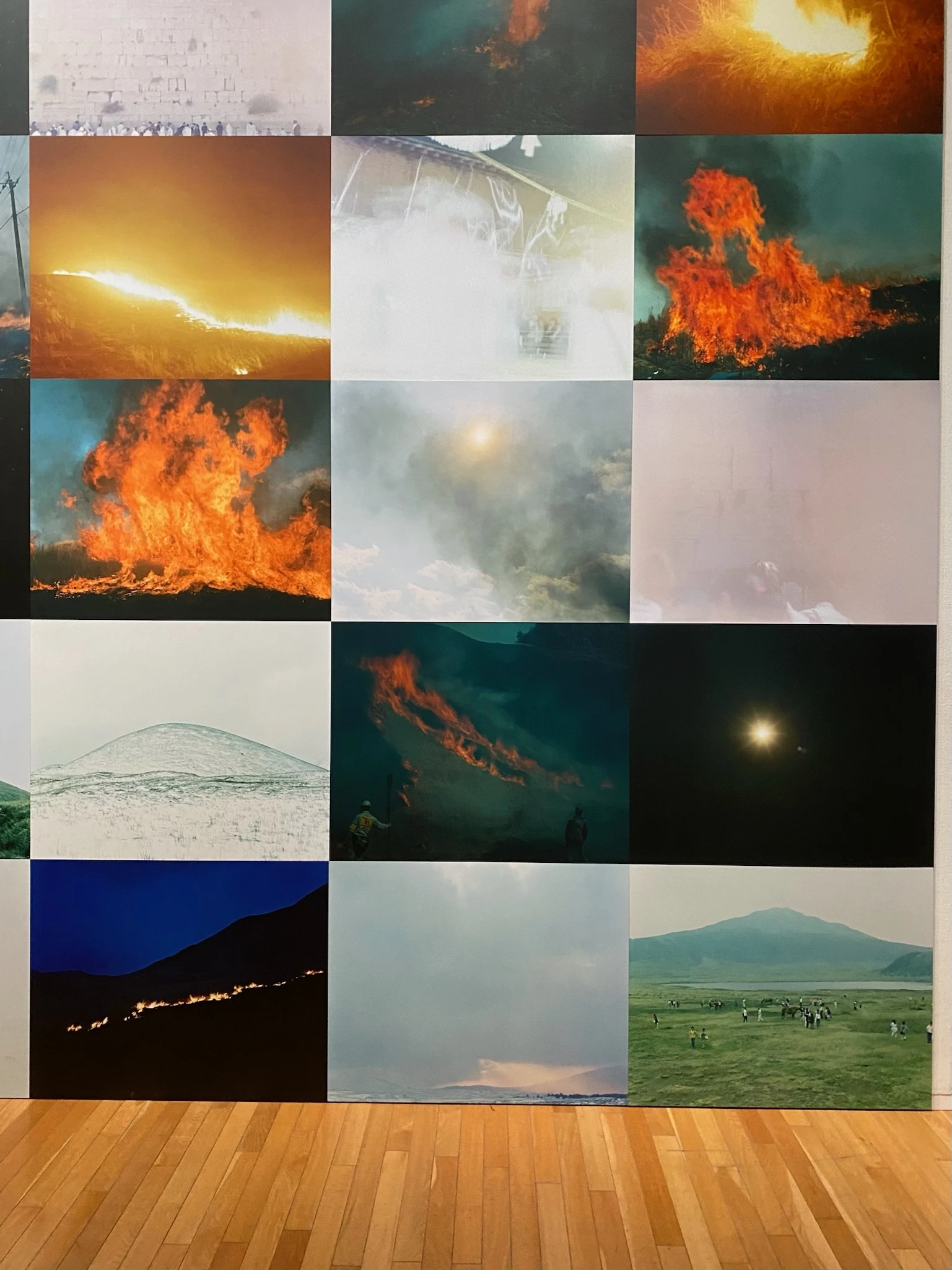 写真家・川内倫子さんの写真展「M/E 球体の上  無限の連なり」の様子。火山の写真や光の写真、山の写真などが組み合わさって一枚の壁になっています。