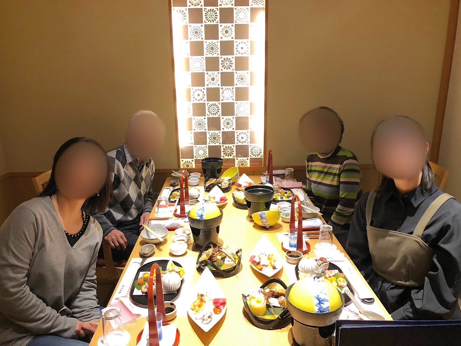 筆者と母、祖父母の写真。和食がテーブルに並んでいる。