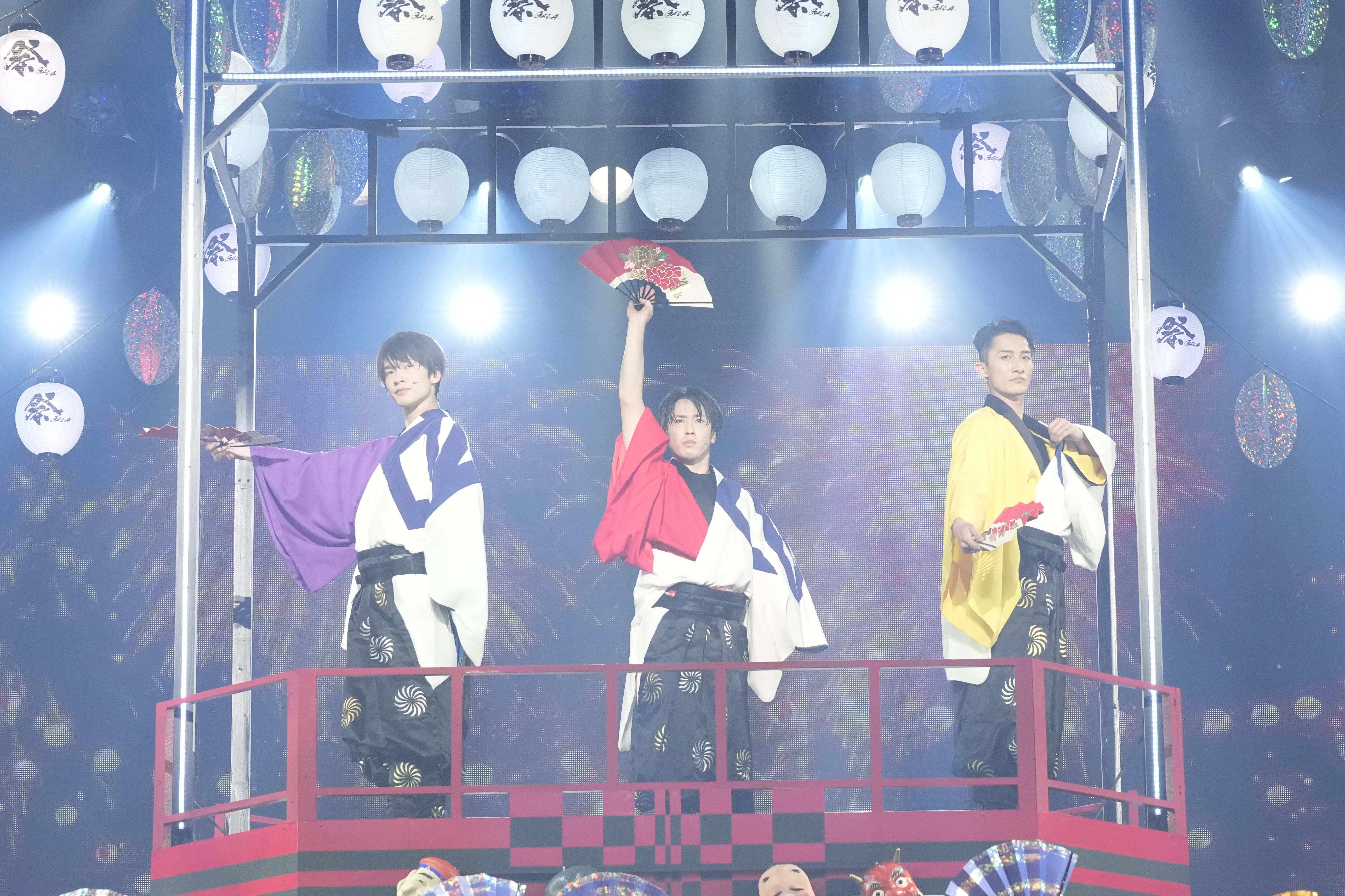 祝祭感あふれる「祭」のシーン。メンバーカラーが効いた衣装で扇を手に決めポーズを取る（左から）深澤さん、宮舘さん、岩本さん
