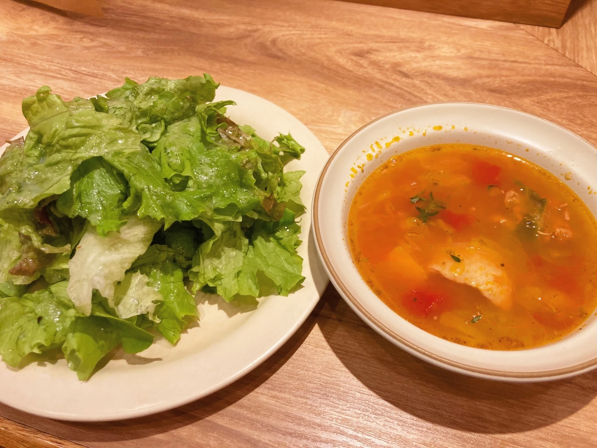 セットのサラダとスープ。葉野菜のサラダ、ハーブの効いたミネストローネ。