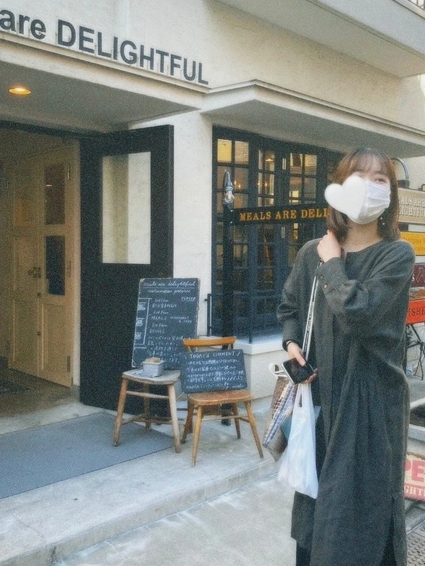渋谷と代々木公園駅の間にあるカフェ「Meals Are Delightful」の前に、グレーのワンピースと「beautiful people」のバッグを着た女の子が立っている写真。