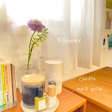 お花とキャンドル、ネイル、本が机の上にのっています。