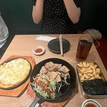 左からチーズじゃがいもチヂミ、サムギョプサル、お通しのスナック菓子と韓国のりを写した写真